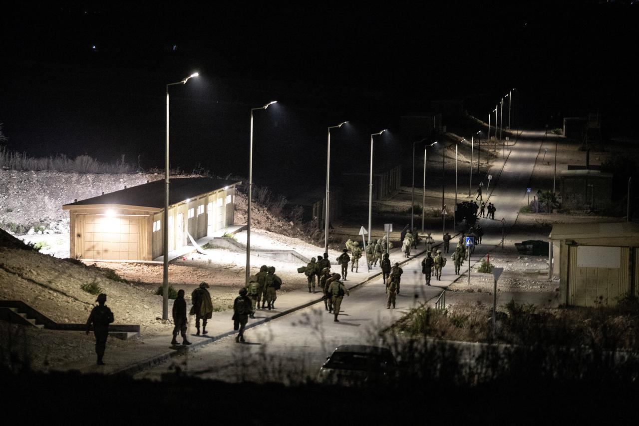 Israeli soldiers walk near the scene where a drone from Lebanon attacked Israel in Binyamina