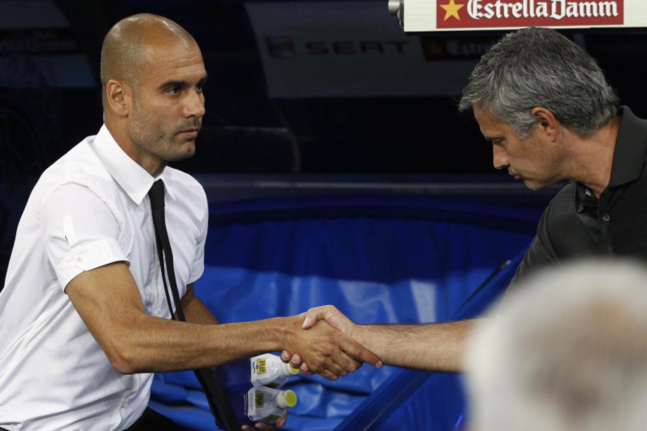 'Real Madrid\'s Jose Mourinho (R) shakes hands with Barcelona\'s coach Pep Guardiola before their Spanish Supercup first leg soccer match at the Santiago Bernabeu stadium in Madrid August 14, 2011.  R