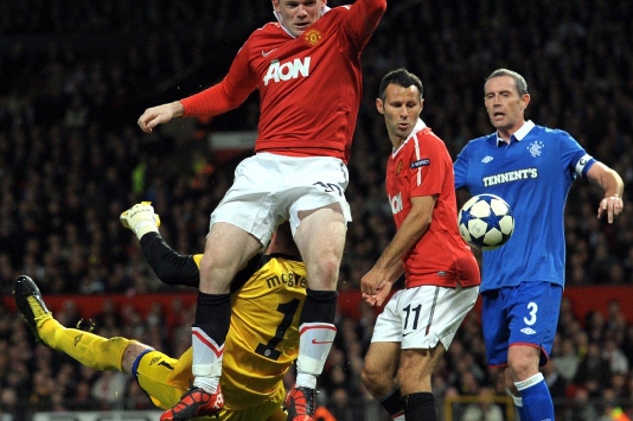 'Manchester United\'s English forward Wayne Rooney collides Rangers\' Scottish goalkeeper Allan McGregor during their UEFA Champions League Group C football game at Old Trafford in Manchester, north-w