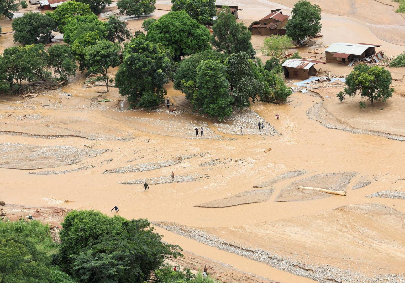 People cross a flooded area in Muloza on the border with Mozambique after the aftermath of Tropical Cyclone Freddy, around 100 km outside Blantyre, Malawi, March 18, 2023. REUTERS/Esa Alexander Photo: ESA ALEXANDER/REUTERS