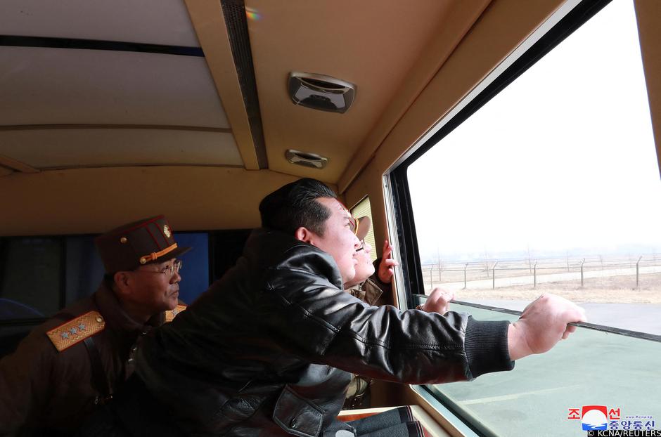 North Korean leader Kim Jong Un looks through a window during the test firing of what state media report is a "new type" of intercontinental ballistic missile (ICBM)