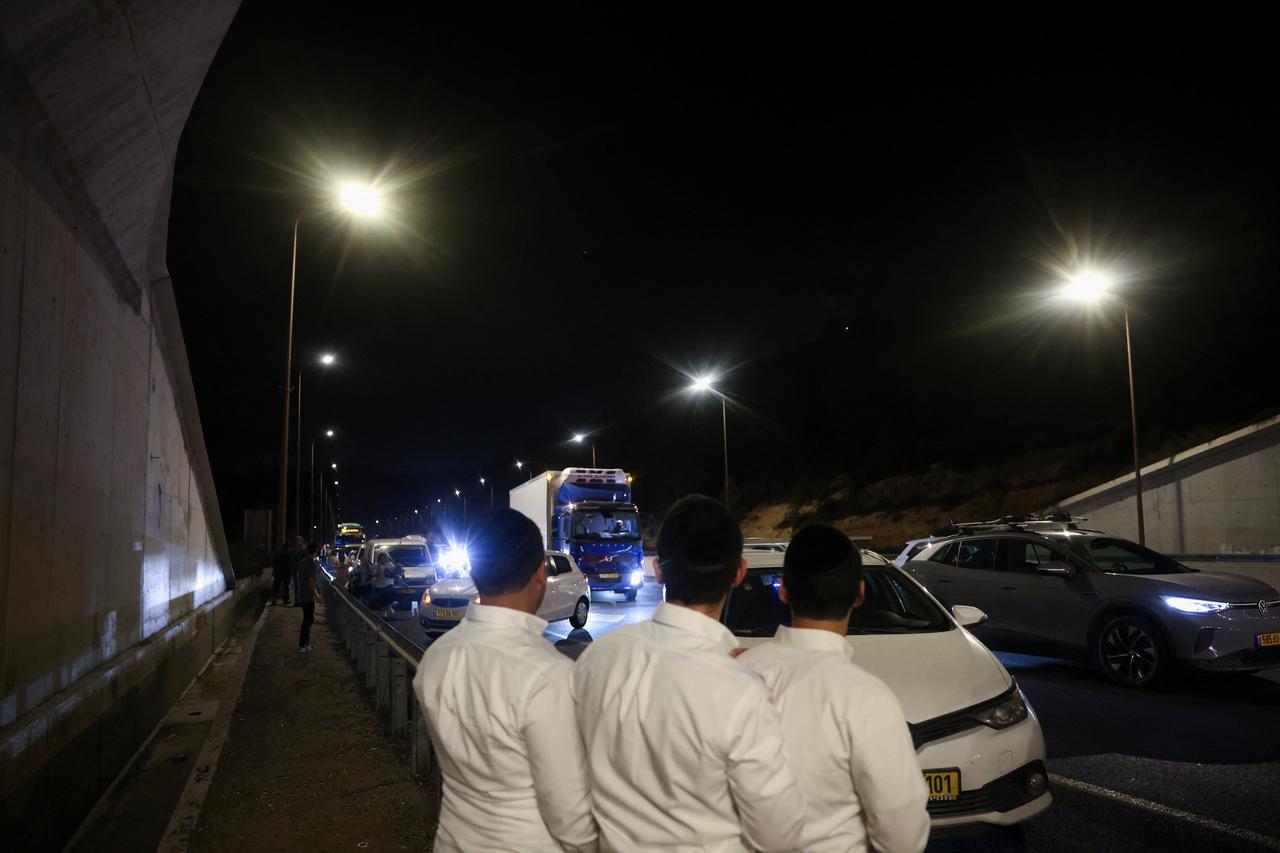 People take shelter during an air raid siren, in central Israel