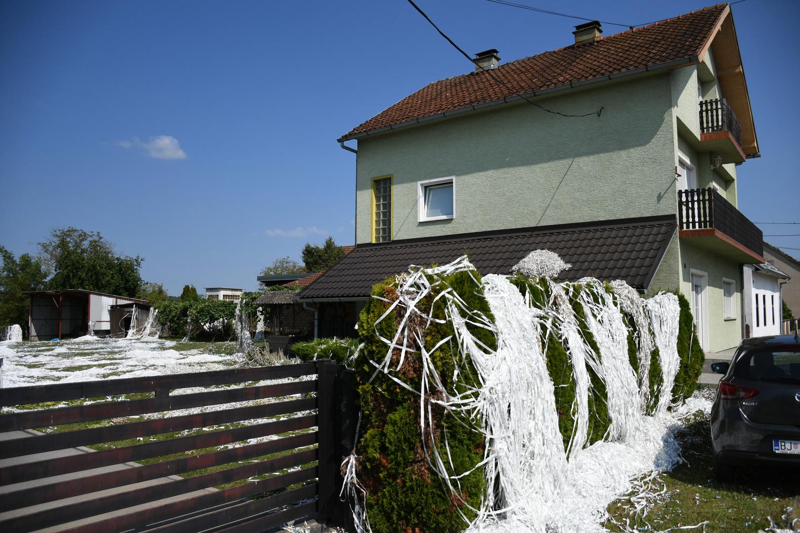 22.07.2023., Garesnica - Pogled na prvu zavara i izgleda kao da je na + 35 stupnjeva dvoriste obiteljske kuce zatrpano snijegom. Medjutim na podrucju Bjelovarsko-bilogorske zupanije njeguje se nesvakidasnji obicaj "slavlja" dolaska kuci majke i novorodjenceta iz bolnice, poznat pod nazivom sipanje. Rodbina, prijatelji i susjedi iskazuju veselje zasipavanjem dvorista perjem i papirima, a neuobicajeni nestasluci postaju ocekivani dio slavlja. Ovo je obicaj koji nema pisana pravila pa on ovisi o "kreativnosti" sipaca. Nakon slavlja, domacini ove obiteljske kuce u Garesnici imati ce pune ruke posla da sve ociste i vrate u prvobitno stanje.  Photo: Damir Spehar/PIXSELL