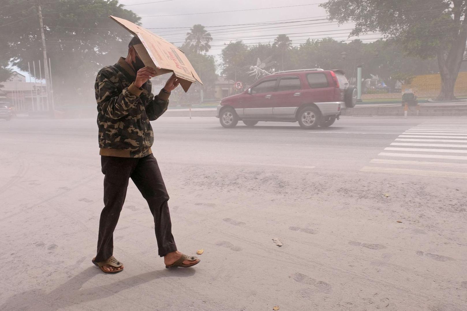 A man uses cardboard to protect himself from ash from the eruption of Indonesia's Mount Merapi?volcano, in Magelang, Central Java province, Indonesia, March 11, 2023. Antara Foto/Anis Efizudin/via REUTERS ATTENTION EDITORS - THIS IMAGE HAS BEEN SUPPLIED BY A THIRD PARTY. MANDATORY CREDIT. INDONESIA OUT. NO COMMERCIAL OR EDITORIAL SALES IN INDONESIA. Photo: ANTARA FOTO/REUTERS