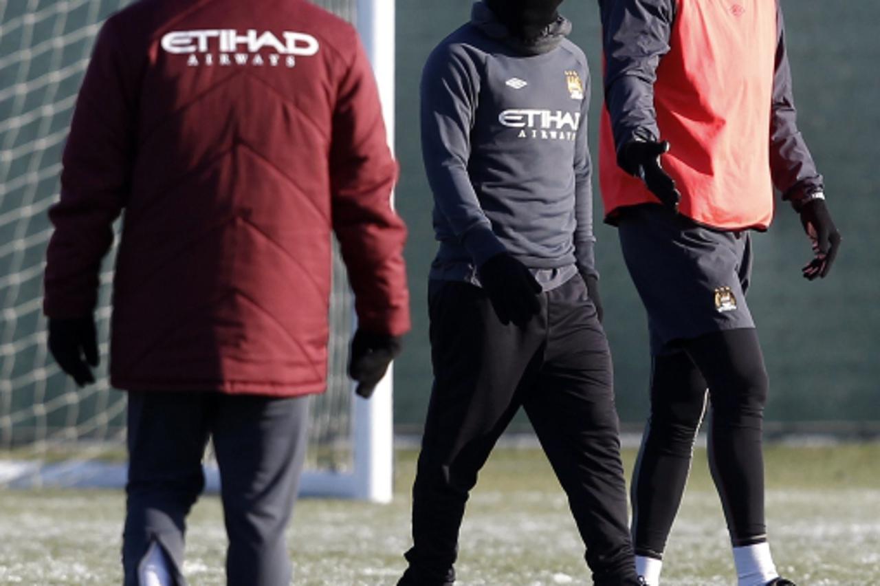 \'Manchester City\'s Roque Santa Cruz (R) and Carlos Tevez (C) walk past manager Roberto Mancini (L) during a training session at the club\'s Carrington training complex in Manchester, northern Englan