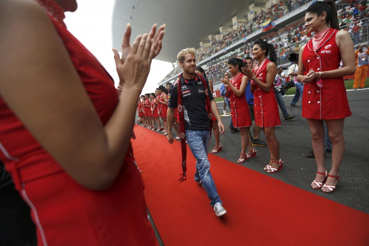 'Grid girls clap as Red Bull Formula One driver Sebastian Vettel of Germany walks on a red carpet during the Indian F1 Grand Prix at the Buddh International Circuit in Greater Noida, on the outskirts 