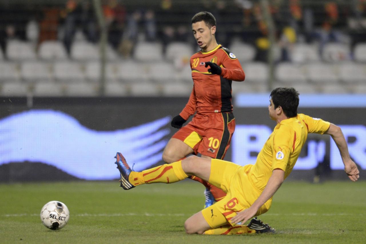 'Belgium's Eden Hazard is tackled by Macedonia's Vance Sikov (R) during their 2014 World Cup qualifying soccer match at the King Baudouin stadium in Brussels March 26, 2013. REUTERS/Laurent Dubrule 