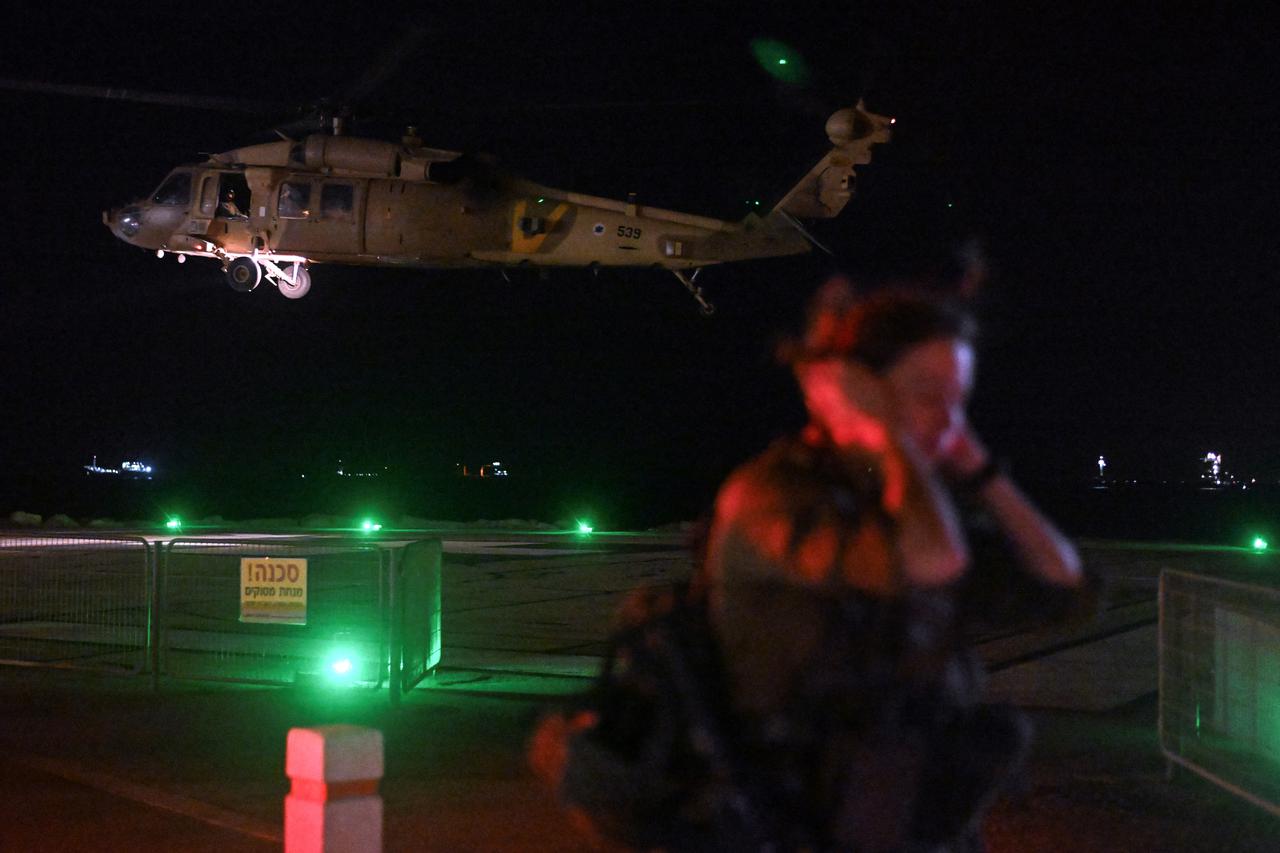 An Israeli soldier stands by as a military helicopter takes off after it dropped off patients that were injured in a drone attack from Lebanon, at Rambam Health Care Campus in Haifa