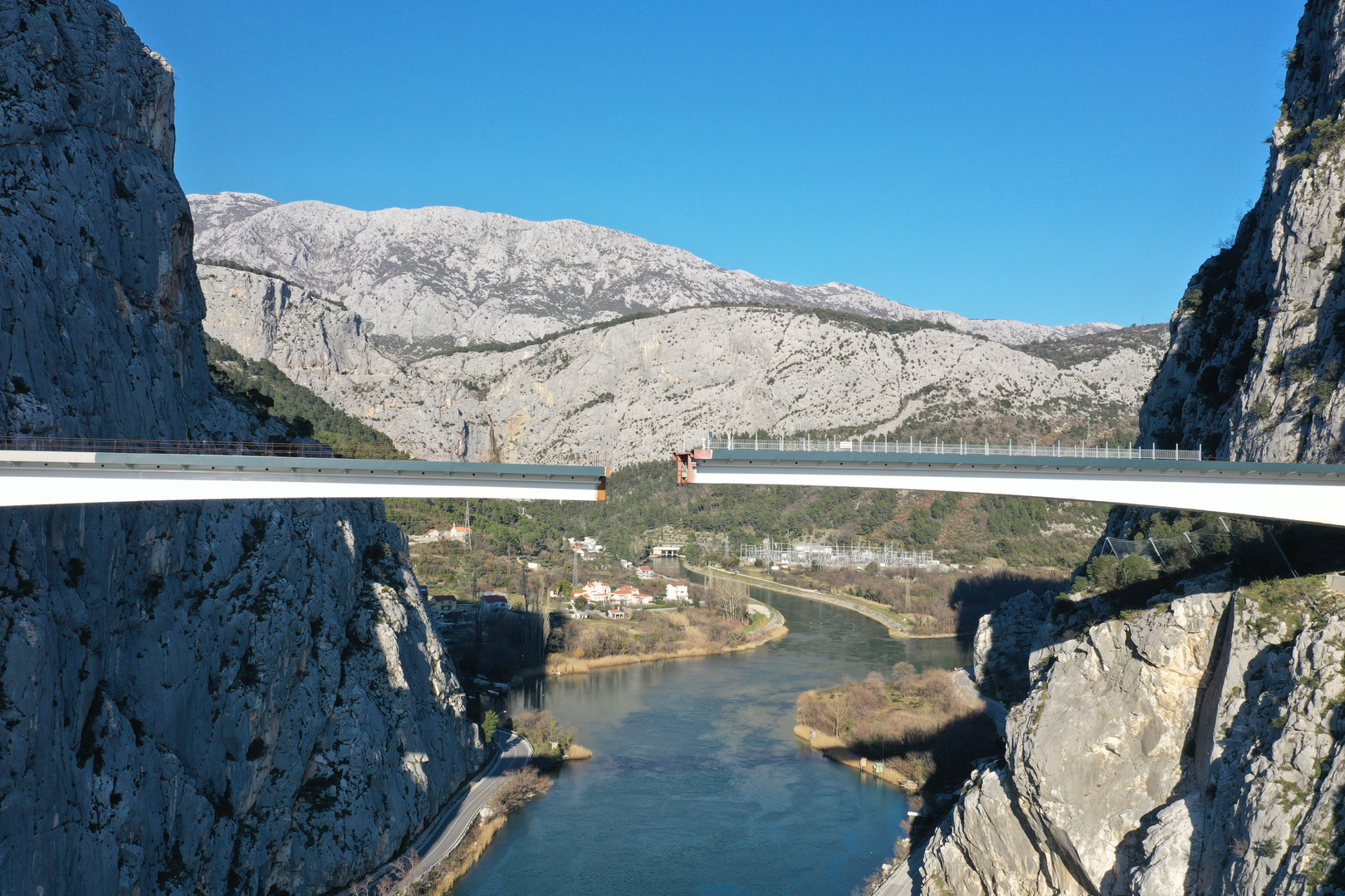 09.02.2023., Omis - Spajanje mosta iznad rijeke Cetine kod Omisa na 70 metara nadmorske visine koji je dio omiske zaobilaznice. Omiska obilaznica jedan od najvecih infrastrukturnih objekata u Splitsko-dalmatinskoj zupaniji, a zaobilaznicu ukljucuju dva tunela i most preko Cetine, tunel Komorjak dug vise od 600 metara, a Omis vise od 500 metara, dok ce most biti u duzini od 216 metara. Investitor je tvrtka Hrvatske ceste, koja je za prvu fazu brze ceste Split - Omis izdvojila 174,5 milijuna kuna, a s radovima se pocelo u rujnu 2019.  Photo: Matko Begovic/PIXSELL