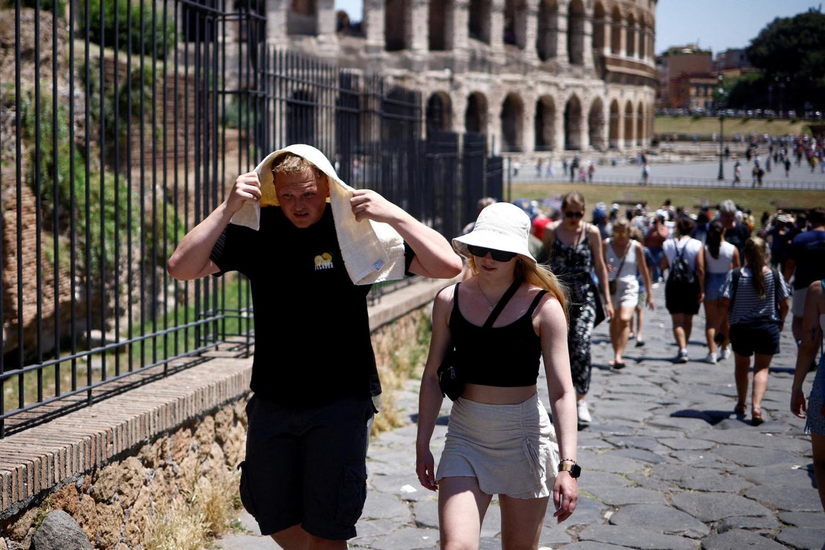 A man shelters from the sun with a towel near the Colosseum during a heatwave across Italy, in Rome, Italy July 11, 2023. REUTERS/Guglielmo Mangiapne Photo: GUGLIELMO MANGIAPANE/REUTERS