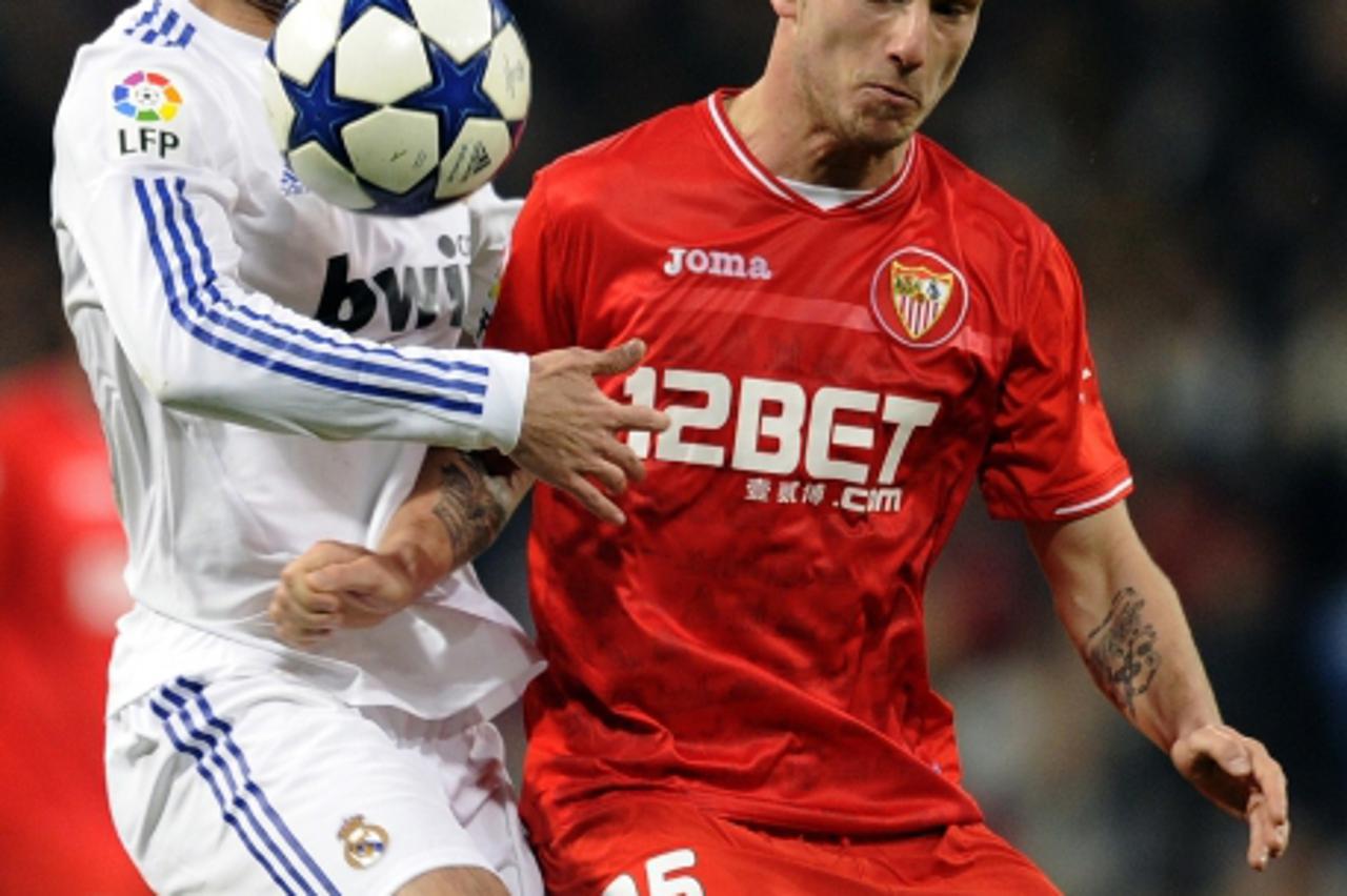 'Real Madrid\'s defender Raul Albiol (L) vies with Sevilla\'s Croatian midfielder Ivan Rakitic (R) during the Spanish King\'s Cup (Copa del Rey) semifinal second-leg football match Real Madrid CF vs S