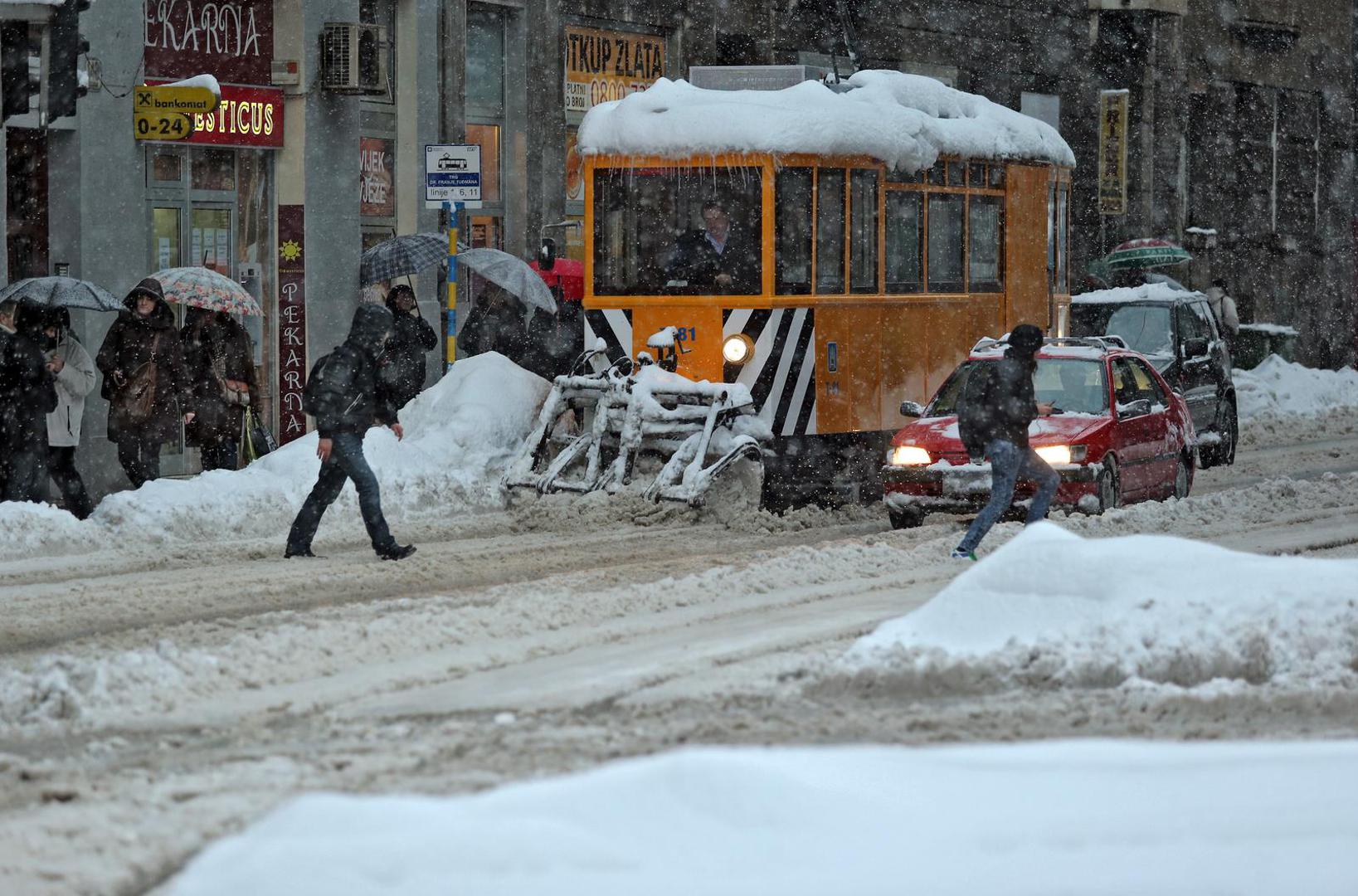 14.01.2013., Ilica, Zagreb - I u vecernjim satima dok sluzbe zaduzene za ciscenje snijega obavaljaju svoj posao gust snijeg i dalje pada te zadaje najvece probleme u prometu.rPhoto: Sanjin Strukic/PIXSELL