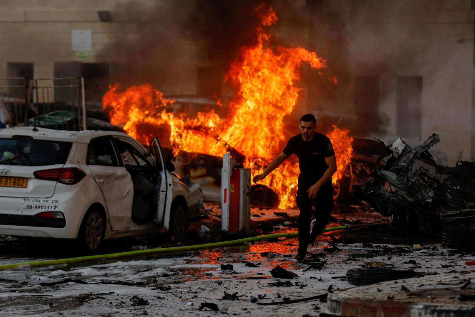 A man runs on a road as fire burns after rockets were launched from the Gaza Strip, in Ashkelon, Israel October 7, 2023. REUTERS/Amir Cohen Photo: AMIR COHEN/REUTERS