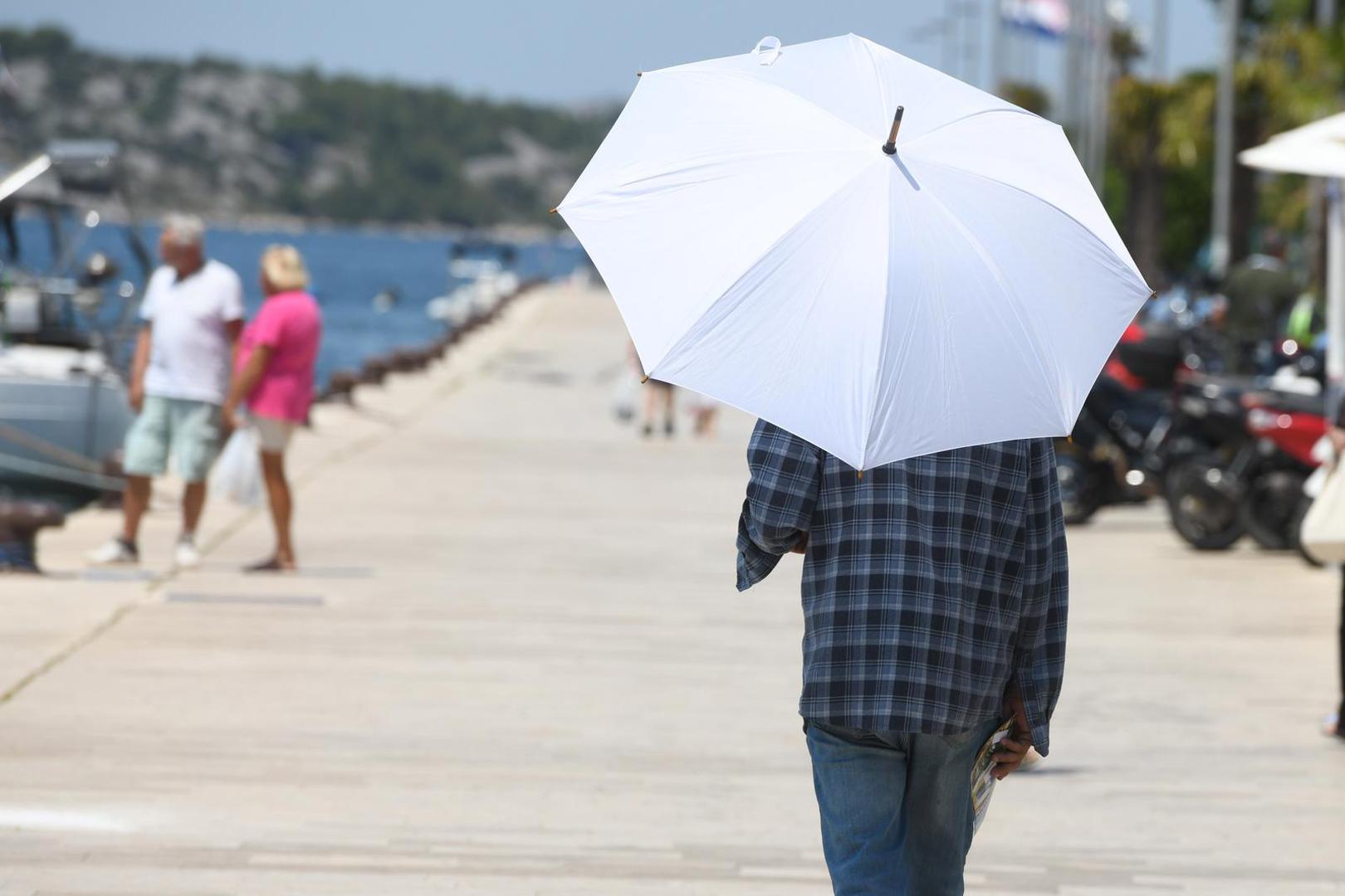 10.07.2023., Sibenik - Spas od vrucina potrazio se na sibneskim ulicama na razne nacine, vodom, kisobranima, sesirima.... Photo: Hrvoje Jelavic/PIXSELL