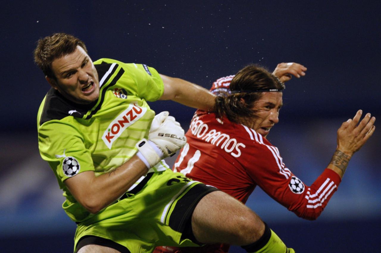 'Sergio Ramos (R) of Real Madrid fights for a ball with goalkeeper Ivan Kelava of Dinamo Zagreb during their Champions League Group D soccer match at the Maksimir stadium in Zagreb September 14, 2011.