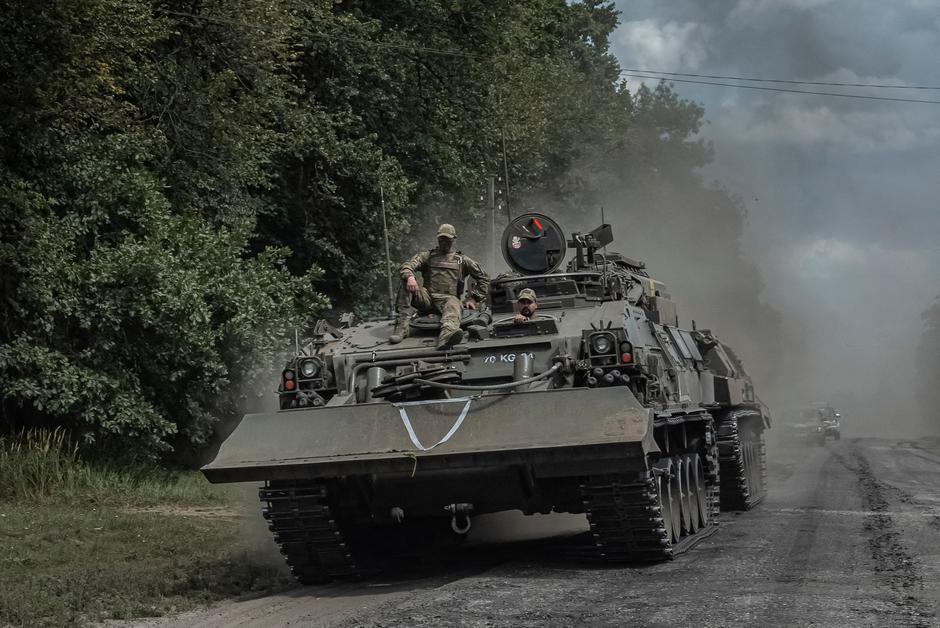 FILE PHOTO: Ukrainian servicemen ride a military vehicle near the Russian border in Sumy region