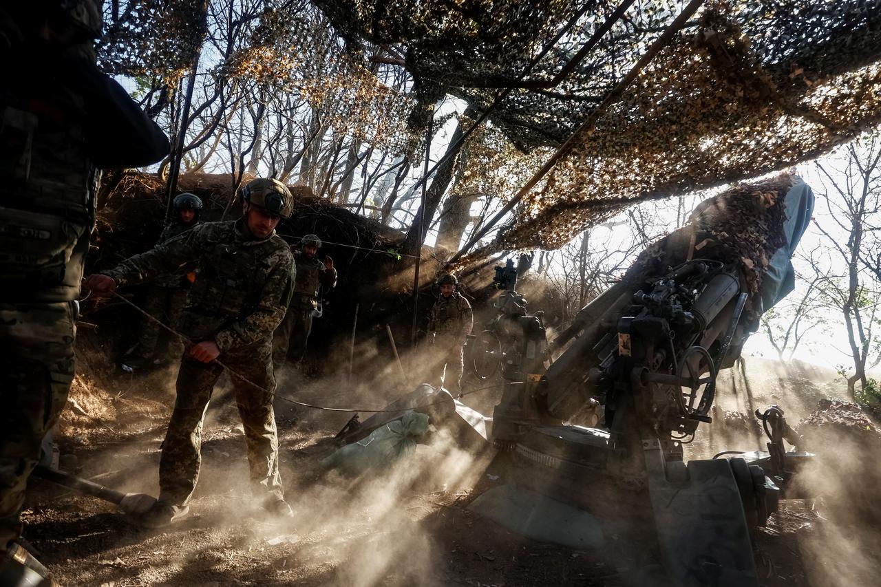 Ukrainian servicemen fire a howitzer towards Russian troops in Donetsk region