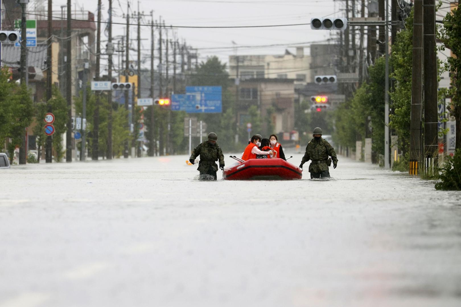 Japanese Self-Defense Force personnel push a boat carrying evacuees in the Fukuoka Prefecture city of Omuta on July 7, 2020, as torrential rain continues to hit Japan's southwestern region of Kyushu. (Kyodo)
==Kyodo
 Photo via Newscom Newscom/PIXSELL