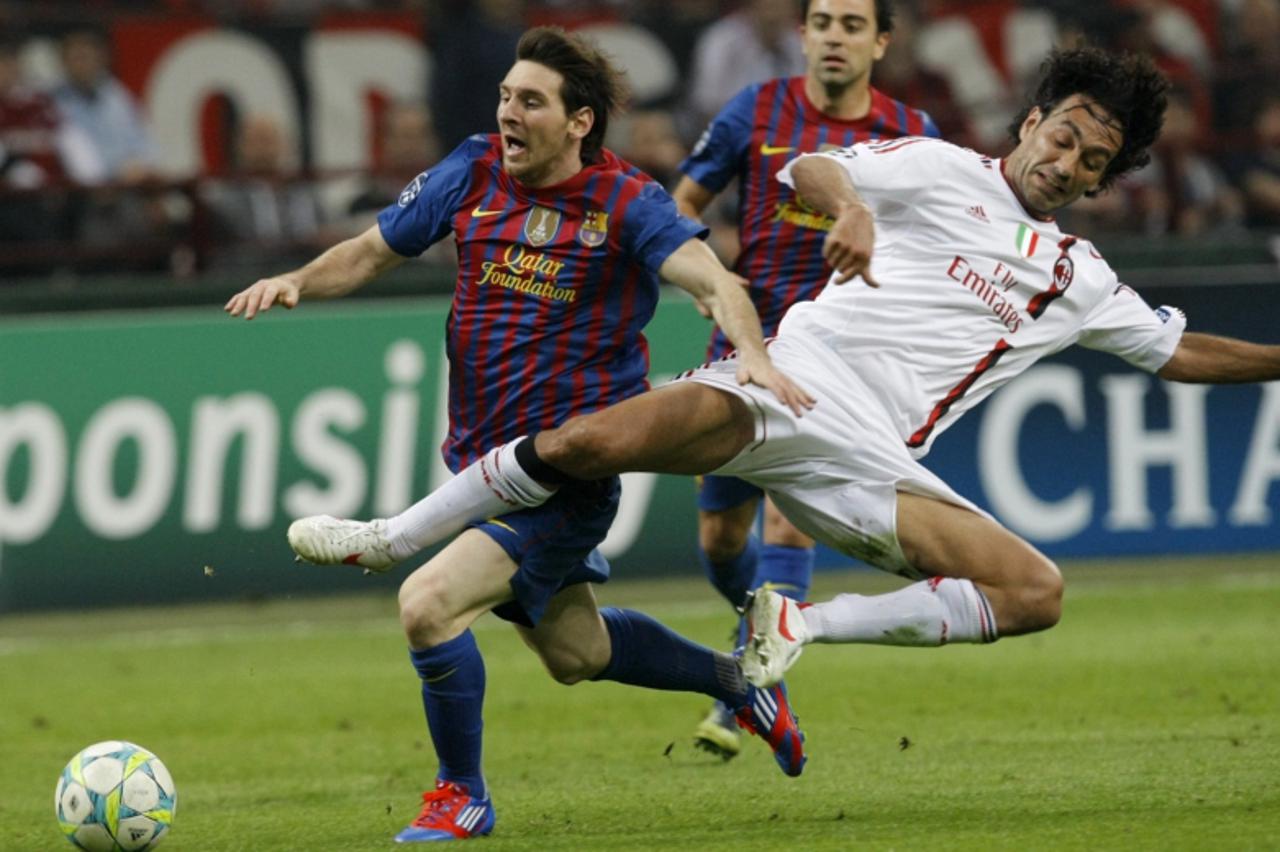 'Barcelona\'s Lionel Messi (L) is challenged by AC Milan\'s Alessandro Nesta during their UEFA Champions League quarter final first leg soccer match at the San Siro stadium in Milan March, 28 2012. RE