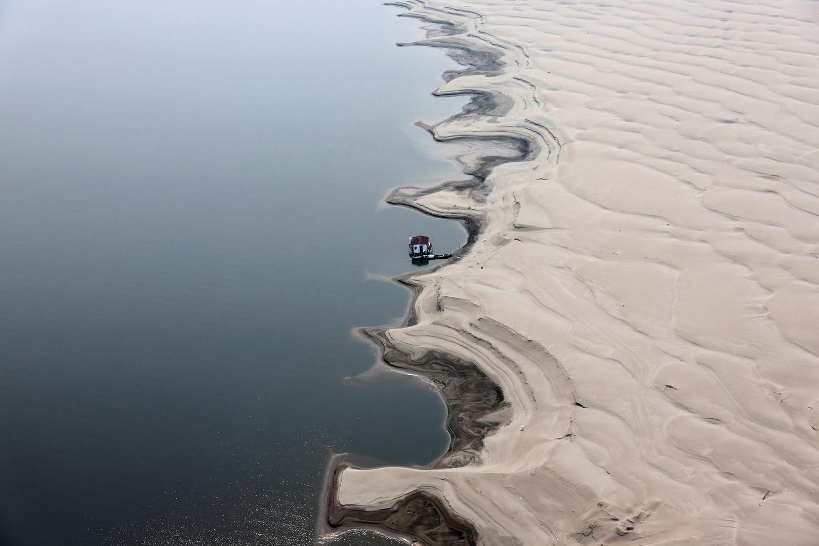 A floating house is seen next to a sandbank at the Solimoes River, one of the largest tributaries of the Amazon River, during a Greenpeace flyover to inspect what the National Center for Monitoring and Early Warning of Natural Disasters (Cemaden) says is the most intense and widespread drought Brazil has experienced since records began in 1950, near Tefe, Amazonas state, Brazil September 17, 2024. REUTERS/Jorge Silva Photo: JORGE SILVA/REUTERS