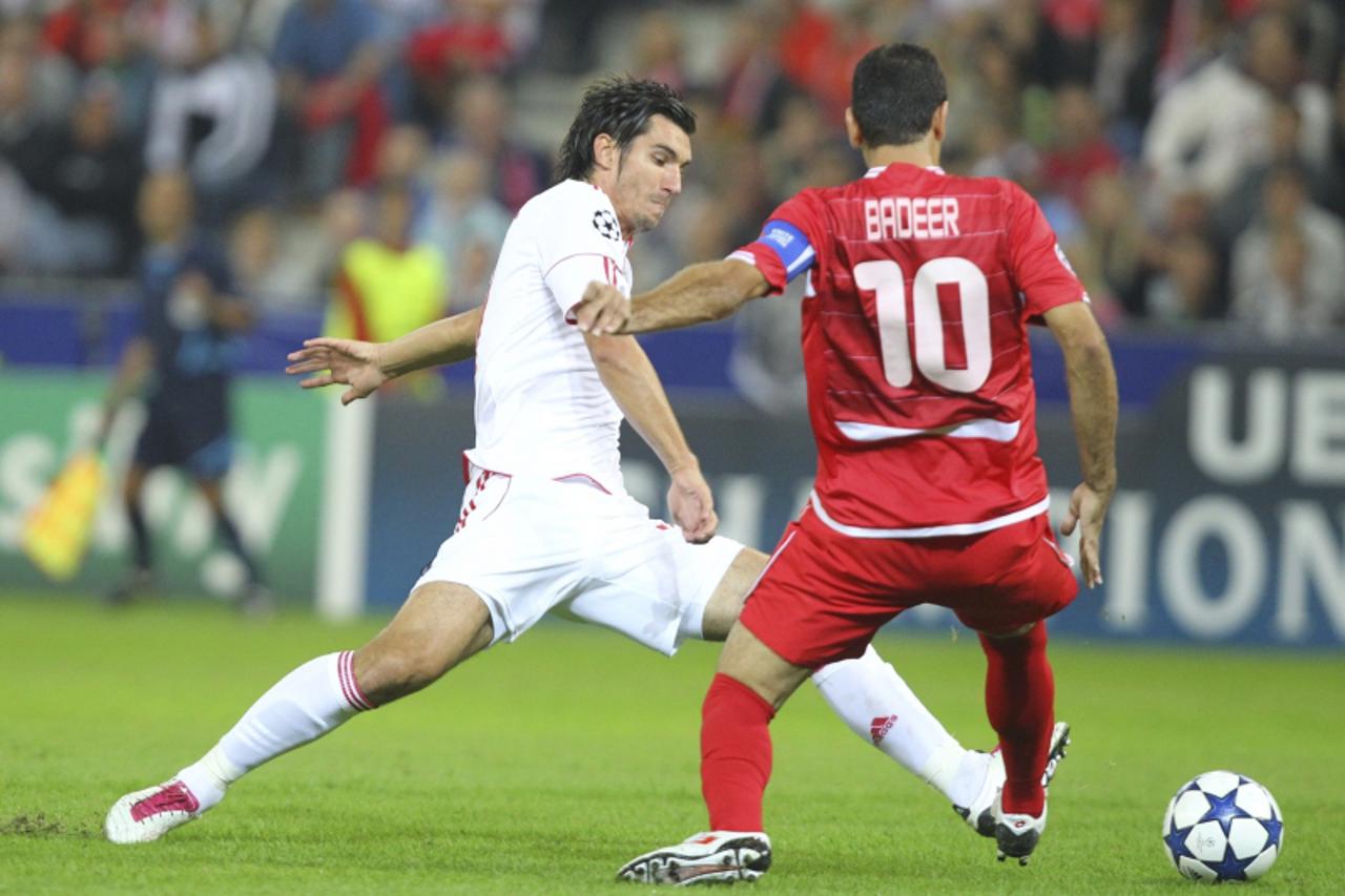 'Red Bull Salzburg\'s Nikola Pokrivac and Hapoel Tel Aviv\'s Walid Badier (R) fight for the ball during their Champions League qualifying soccer match in Salzburg August 18, 2010.   REUTERS/Dominic Eb