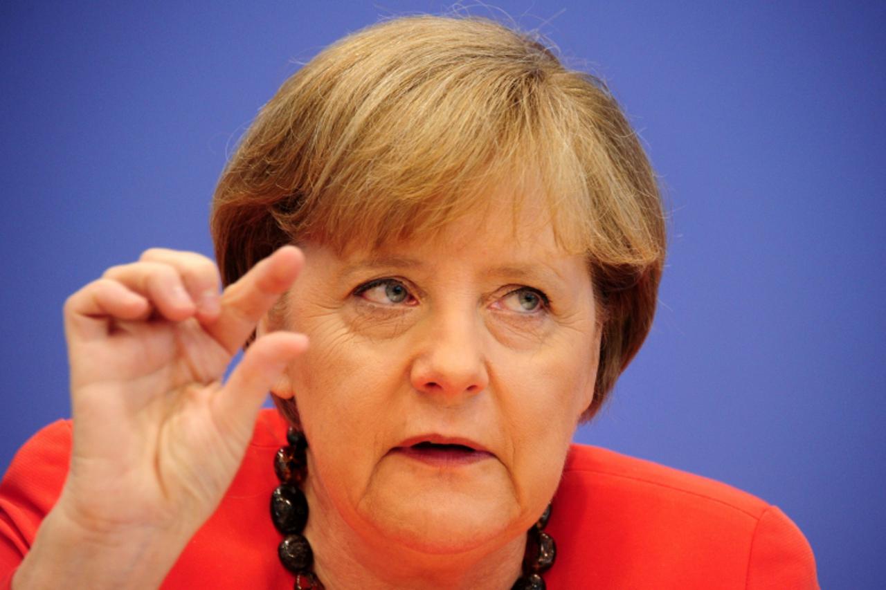 'German Chancellor Angela Merkel is pictured by photographers as she arrives to address holds her traditional annual summer press  conference in Berlin on July 22, 2011, one day after the eurozone sum