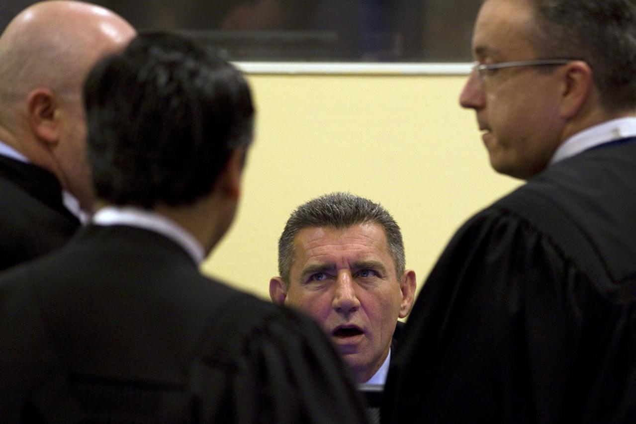 \'Former Croatian Army General Ante Gotovina (C) talks to his defence team in the court room before the International Criminal Tribunal for the former Yugoslavia (ICTY) as it delivers its judgment in 