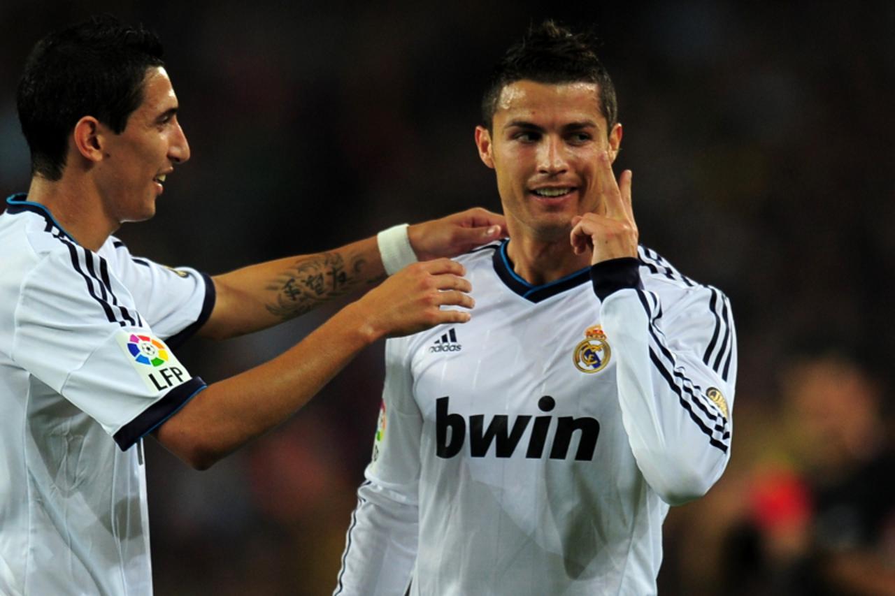 'Real Madrid\'s Portuguese forward Cristiano Ronaldo (R) celebrates after scoring a goal during the Spanish League Clasico football match FC Barcelona vs Real Madrid CF on October 7, 2012 at the Camp 