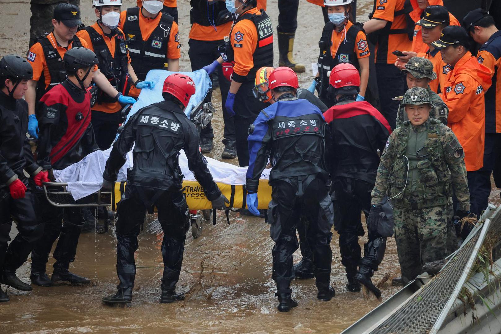 Rescue workers carry the body of a victim recovered during a search and rescue operation near an underpass that has been submerged by a flooded river caused by torrential rain in Cheongju, South Korea, July 16, 2023.   REUTERS/Kim Hong-ji Photo: KIM HONG-JI/REUTERS