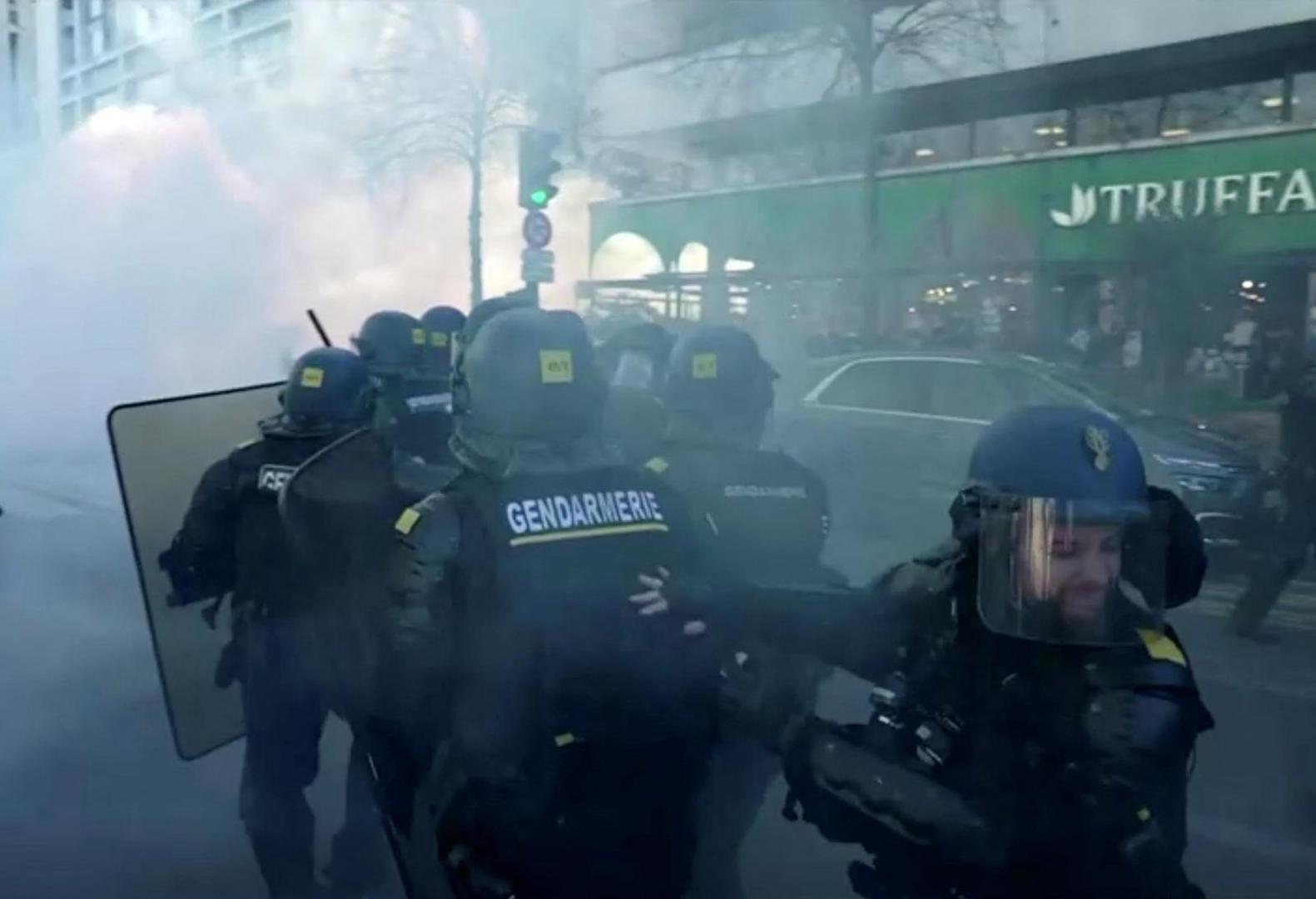 French police use teargas while facing demonstrators in this screen grab taken from a video during a "Convoi de la liberte" (The Freedom Convoy), a vehicular convoy to protest coronavirus disease (COVID-19) vaccine and restrictions in Paris, France, February 12, 2022. REUTERS via Reuters TV Photo: REUTERS TV/REUTERS