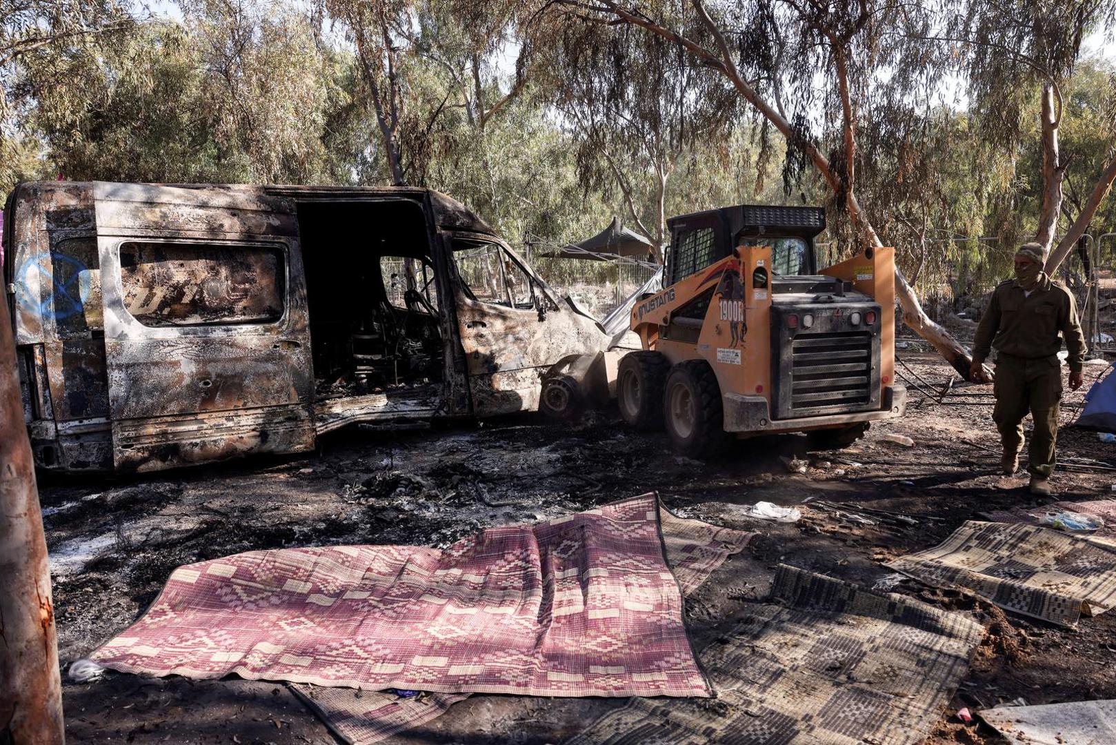 An Israeli soldier glances at a destroyed vehicle at the site of an attack on the Nova Festival by Hamas gunmen from Gaza, near Israel's border with the Gaza Strip, in southern Israel, October 12, 2023. REUTERS/Ronen Zvulun Photo: RONEN ZVULUN/REUTERS