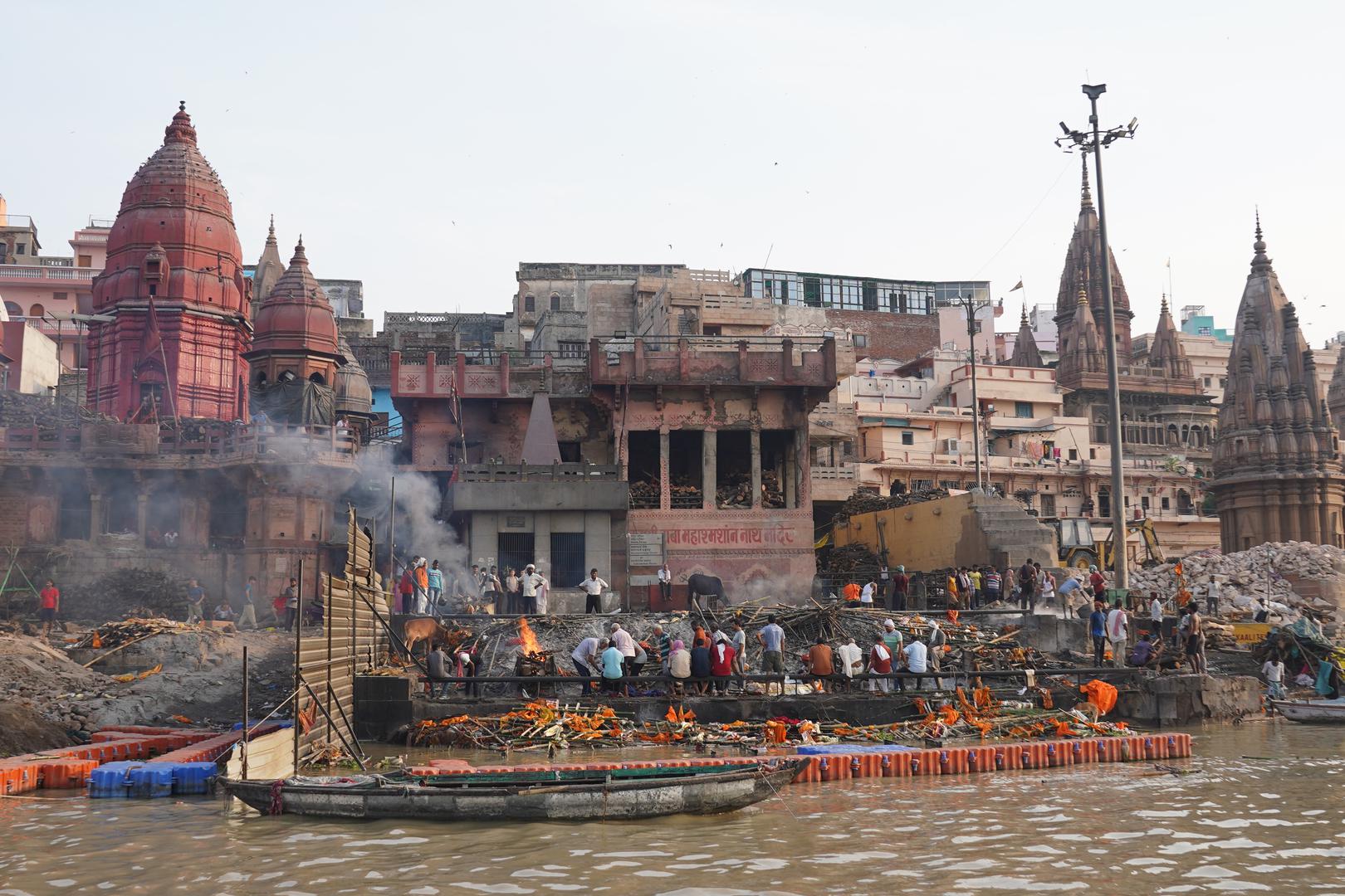 19 July 2024, India, Varanasi: Relatives watch as corpses are burned on funeral pyres by the Ganges. Photo: Anne-Sophie Galli/dpa Photo: Anne-Sophie Galli/DPA