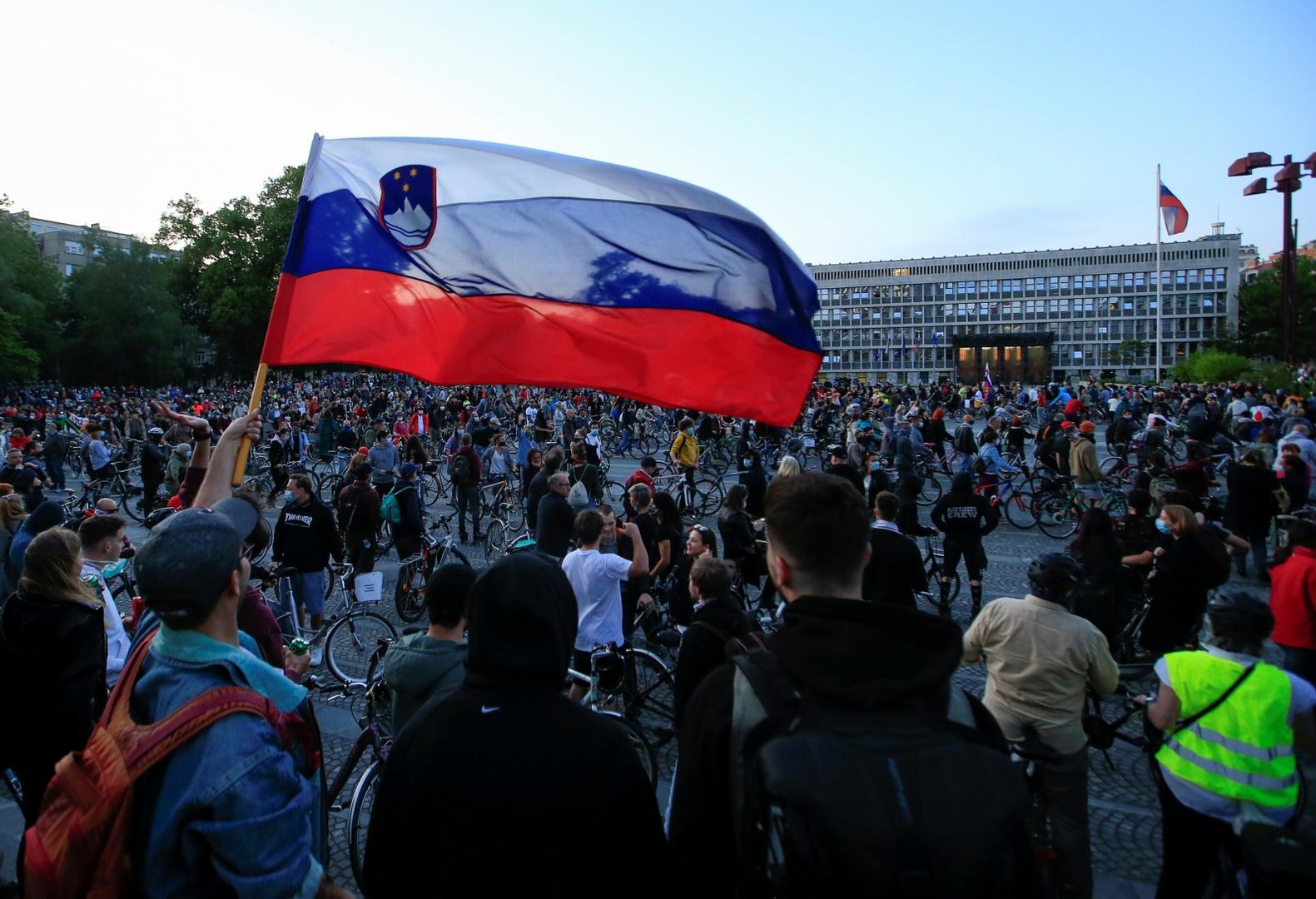 Protesters ride bicycles during an anti-government protest in Ljubljana A protester holds Slovenian flag during an anti-government demonstration, as the spread of the coronavirus disease (COVID-19) continues, in Ljubljana, Slovenia May 8, 2020. REUTERS/Borut Zivulovic BORUT ZIVULOVIC