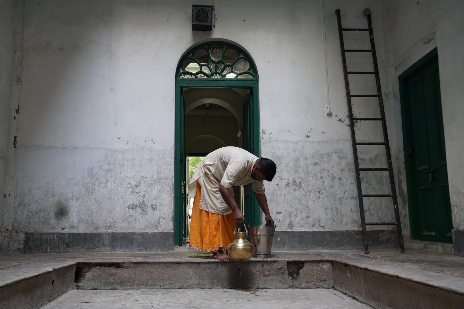 19 July 2024, India, Varanasi: The Hindu priest Kalikant Dubey brings water from the Ganges to the Mukti Bhawan (House of Salvation). Hindus believe that this can wash away one's sins. Photo: Anne-Sophie Galli/dpa Photo: Anne-Sophie Galli/DPA