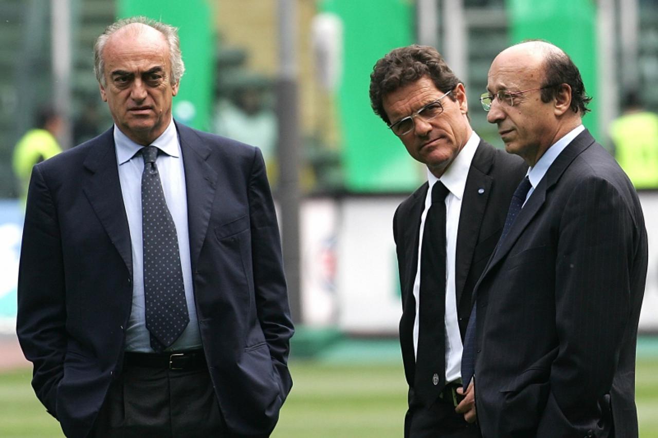 'Antonio Giraudo (L), managing director of Italian soccer team Juventus, coach Fabio Capello (C) and Juventus General Manager Luciano Moggi walks on the pitch at the Delle Alpi stadium in Turin before