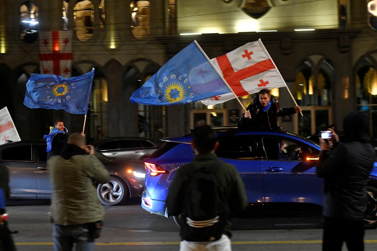 Supporters of the Georgian Dream party celebrate after the announcement of exit poll results in Tbilisi