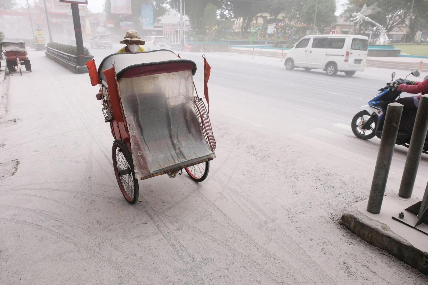 A pedicab passes on a road covered by ash from the eruption of Indonesia's Mount Merapi?volcano, in Magelang, Central Java province, Indonesia, March 11, 2023. Antara Foto/Anis Efizudin/via REUTERS ATTENTION EDITORS - THIS IMAGE HAS BEEN SUPPLIED BY A THIRD PARTY. MANDATORY CREDIT. INDONESIA OUT. NO COMMERCIAL OR EDITORIAL SALES IN INDONESIA. Photo: ANTARA FOTO/REUTERS