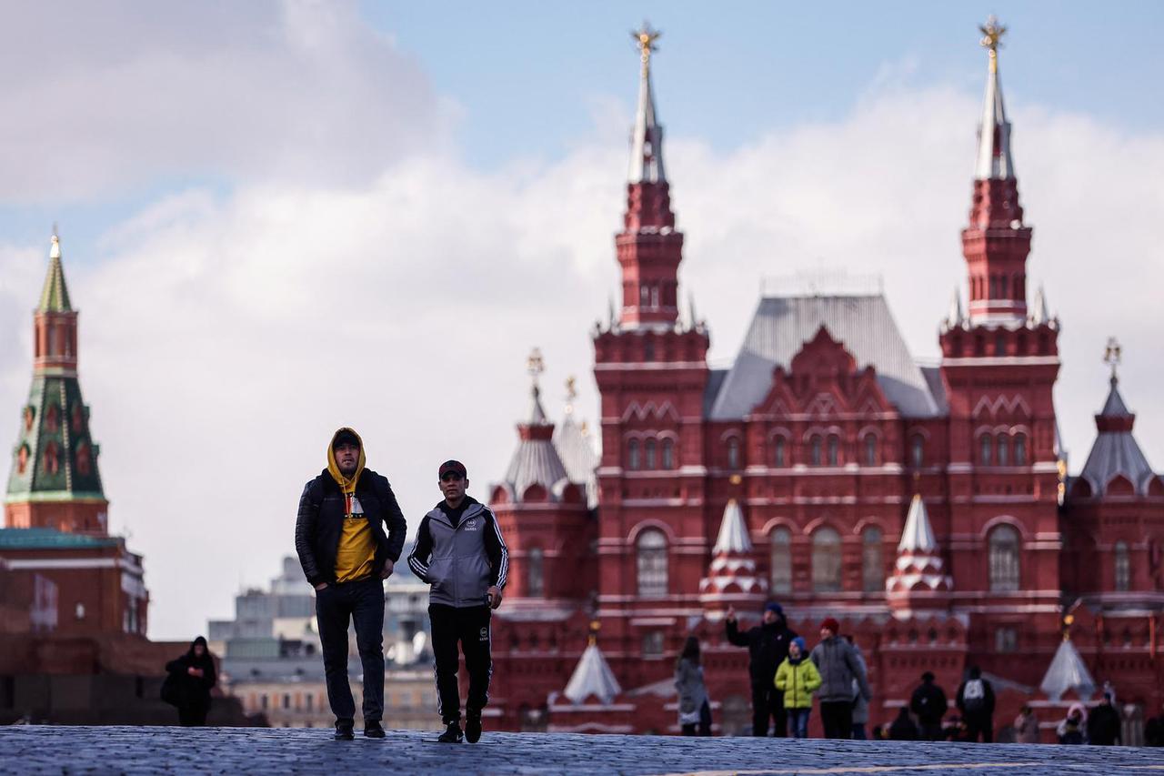 People walk at the Red Square on a sunny day in Moscow