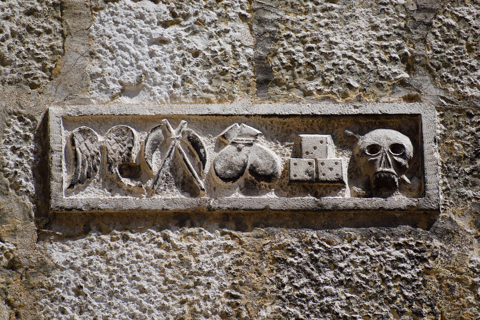 Nalazi se na osam metara visine. Vjeruje se da znači "Lažljivim ustima slijedi smrt", no to je teorija. Još je neodgonetnut. Na njemu su simboli vage, domina, lubanje...