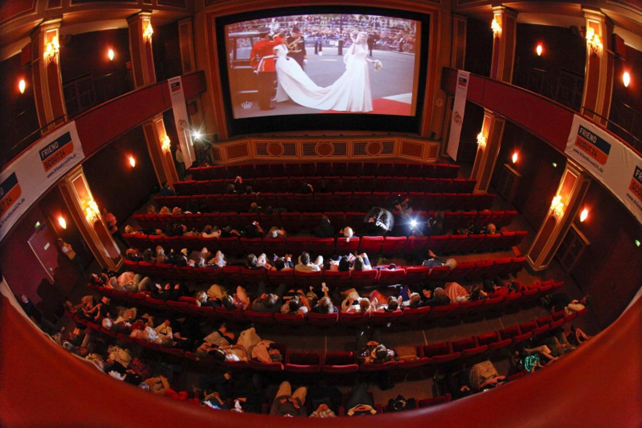 'People attend a public viewing of the wedding of Britain\'s Prince William and Kate Middleton at a local cinema in downtown Munich on April 29, 2011.  REUTERS/Michael Dalder    (GERMANY - Tags: SOCIE