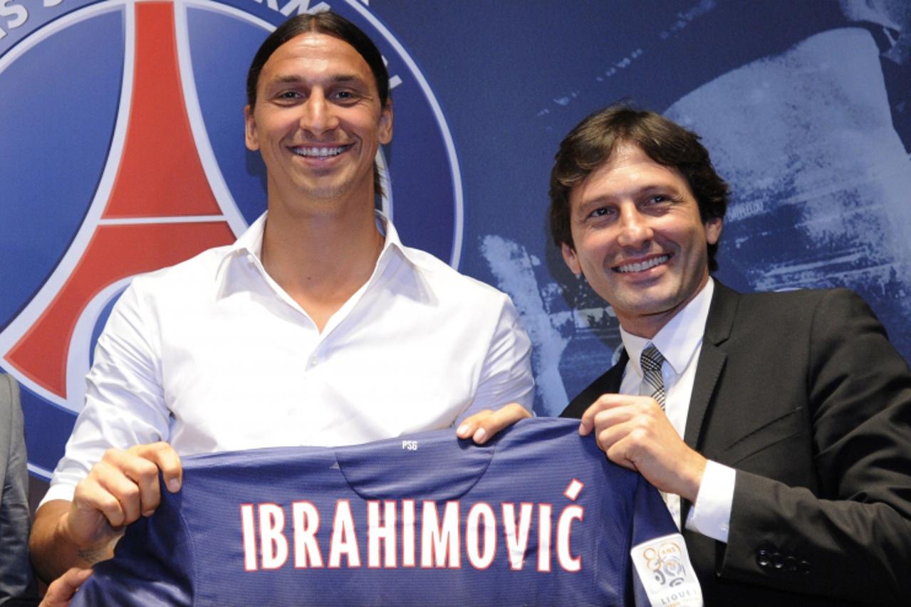 'Paris Saint-Germain (PSG) football club\'s newly recruited Sweden striker Zlatan Ibrahimovic (L), poses with his new jersey next to Paris Saint-Germain (PSG) football club\'s Brazilian sporting direc