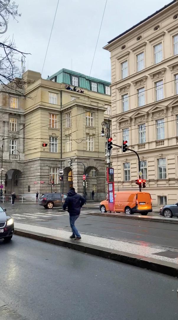 People watch from a roof following a shooting at one of the buildings of Charles University, in Prague, Czech Republic, December 21, 2023, as seen in this screen grab taken from a social media video. Ivo Havranek/via REUTERS  THIS IMAGE HAS BEEN SUPPLIED BY A THIRD PARTY. MANDATORY CREDIT. NO RESALES. NO ARCHIVES. Photo: IVO HAVRANEK/REUTERS