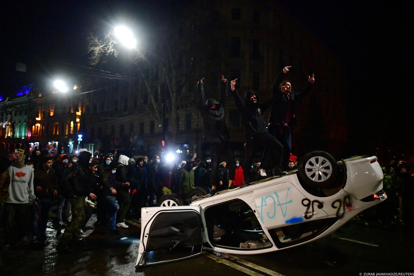 SENSITIVE MATERIAL. THIS IMAGE MAY OFFEND OR DISTURB    Demonstrators gesture as they stand on an overturned car during a protest against a draft law on "foreign agents", which critics say represents an authoritarian shift and could hurt Georgia's bid to join the European Union, in Tbilisi, Georgia, March 9, 2023. REUTERS/Zurab Javakhadze Photo: ZURAB JAVAKHADZE/REUTERS