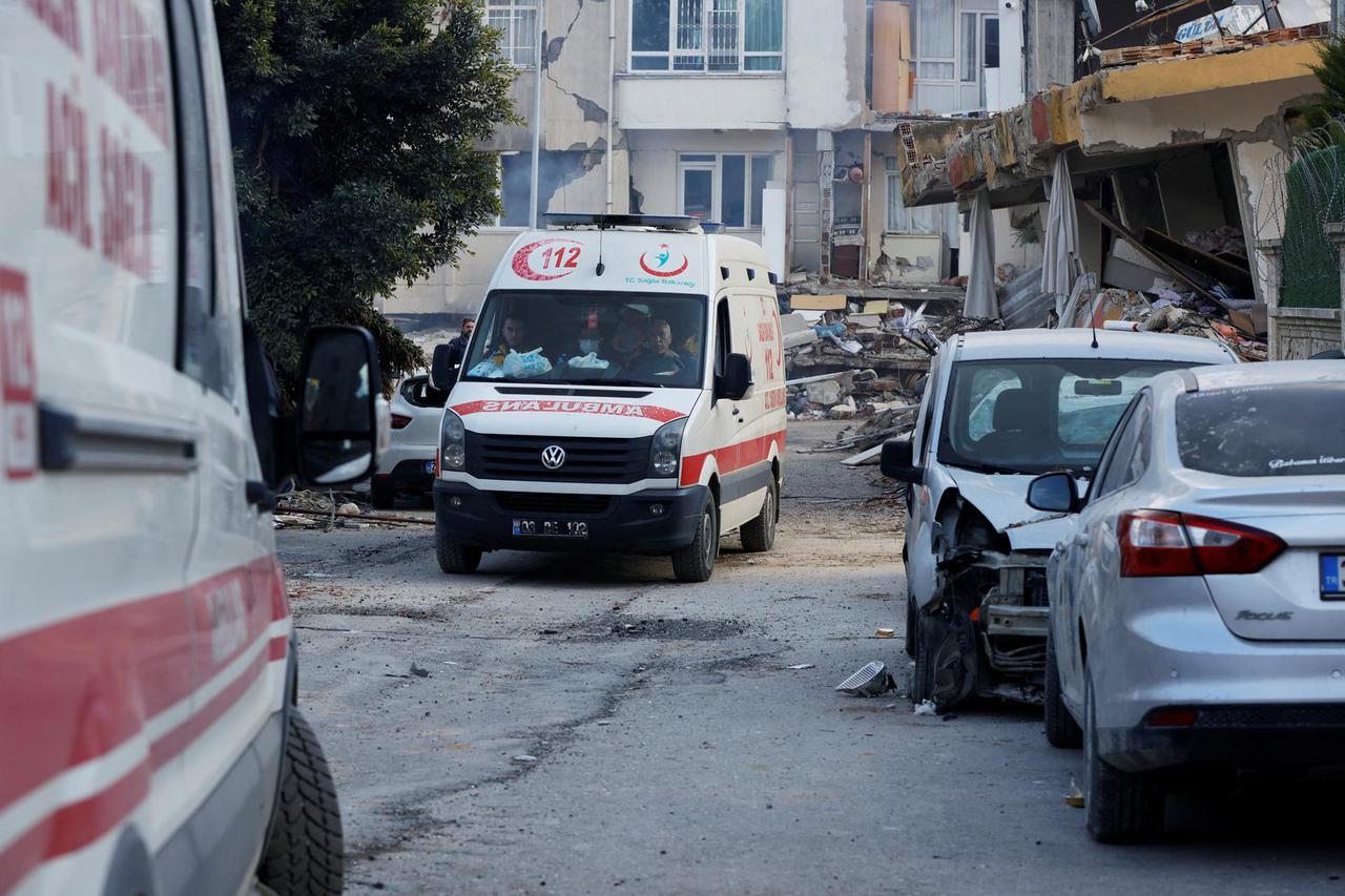 Ambulances drive along a destroyed street, following the deadly earthquake in Hatay