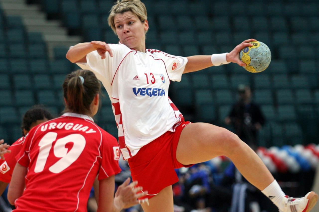 'Croatia\'s Lidija Horvat (R) shoots to score past Uruguay\'s Alejandra Ferrari during their preliminary round match at Women\'s World Handball Championships in St. Petersburg December 10, 2005. Croat