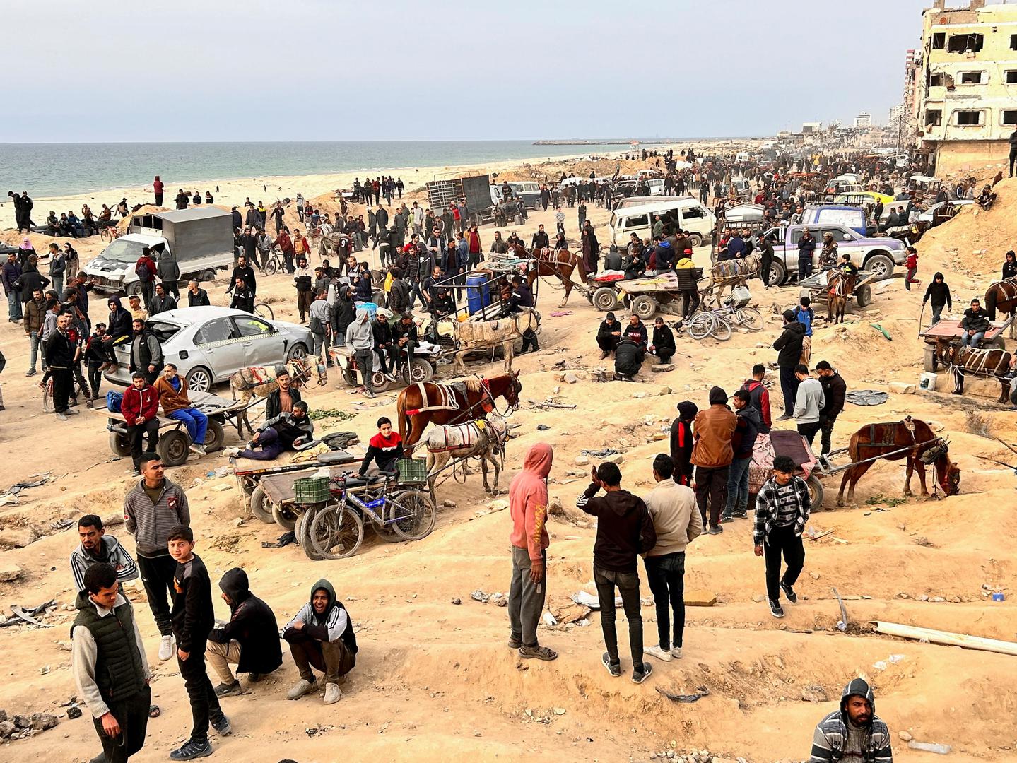 FILE PHOTO: Palestinians gather as they wait for trucks carrying bags of flour to arrive, near an Israeli checkpoint, amid the ongoing conflict between Israel and Hamas, in Gaza City February 26, 2024. REUTERS/Mahmoud Issa/File Photo Photo: MAHMOUD ISSA/REUTERS