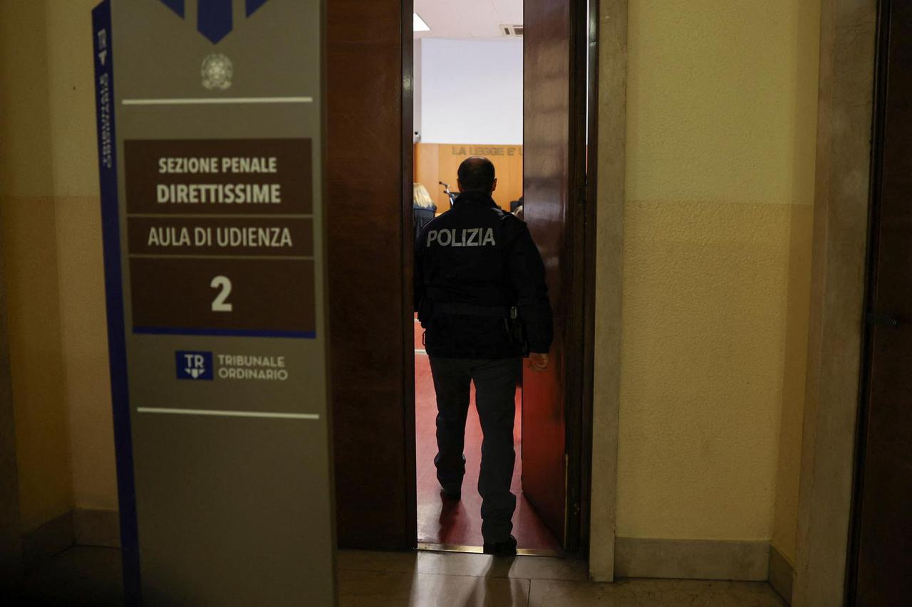 Police officer enters a courtroom at Milan Court of Justice