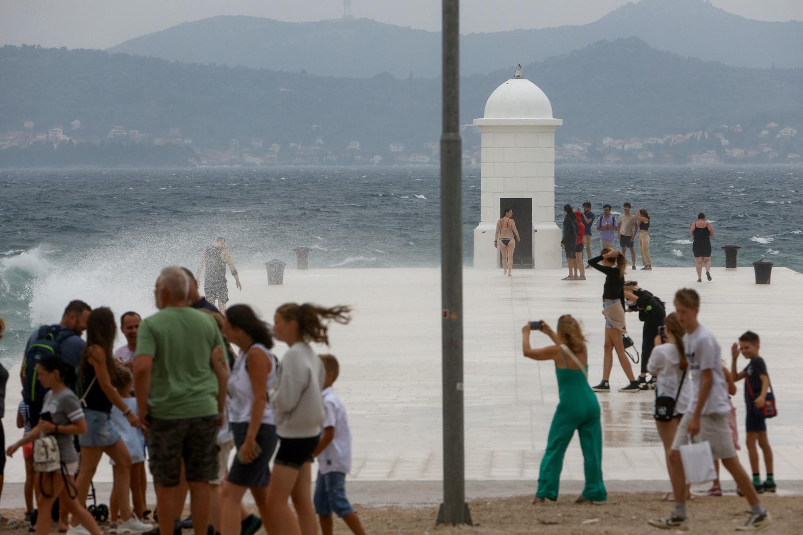 28.08.2023., Zadar - Kisa i jako jugo nisu omeli turiste da prosetaju rivom. Photo: sime zelic/PIXSELL