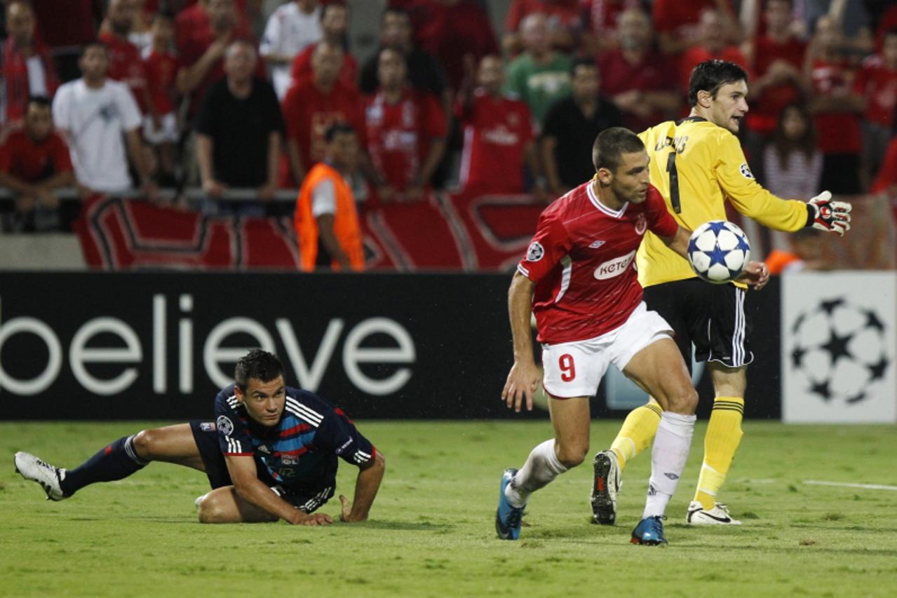 'Hapoel Tel Aviv\'s Etey Schechter (C) challenges Olympique Lyon\'s Dejan Lovren (L) and Hugo Lloris during their Champions League Group B soccer match at Bloomfield stadium in Tel Aviv September 29, 