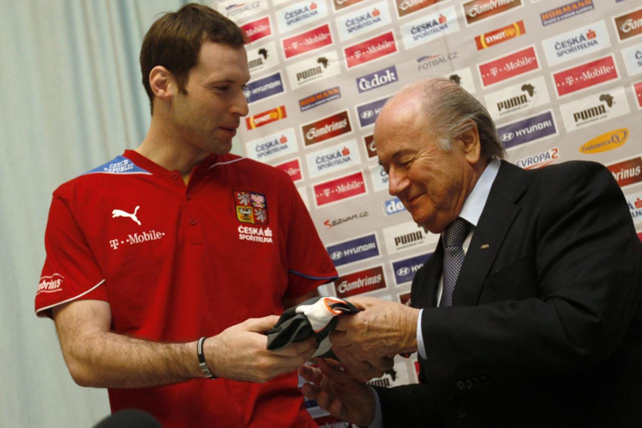 \'Czech national team goalkeeper Petr Cech (L) presents FIFA President Sepp Blatter with his jersey during a news conference in Prague February 8, 2011. REUTERS/Petr Josek (CZECH REPUBLIC - Tags: SPOR